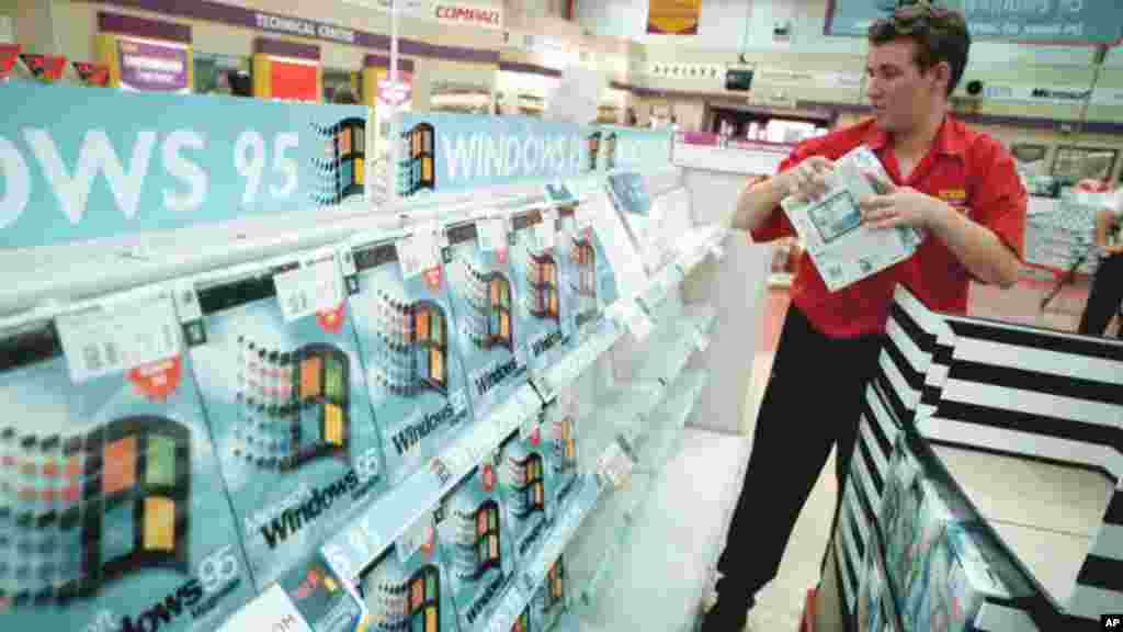 A worker packs the shelves of the computer shop PC World, at Croydon in south London, Aug. 23, 1995, with copies of the Microsoft Windows 95 computer package.