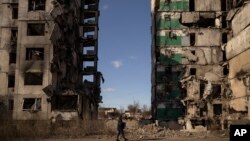 Un hombre camina junto a un bloque de apartamentos al que le falta la sección central después de ser alcanzado por un ataque aéreo, hace un año, en Borodyanka, Ucrania, el jueves 2 de marzo de 2023.