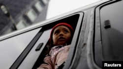 ARCHIVO - Una niña migrante procedente de Centroamérica observa los edificios desde un autobús a su llegada a Ciudad de México en diciembre de 2021.