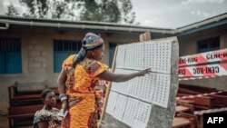 Une femme cherche son nom sur son lieu de vote avant de voter dans le quartier Kasanga-Ndindi de Beni le 31 mars 2019. (Photo: Luke DENNISON / AFP)