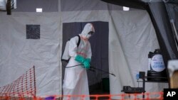 Jami'in lafiya na tsaftace rumfar jinyar masu Ebola a gundumar Mubende, Uganda, Nov. 1, 2022. 