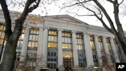 Pejalan kaki berjalan di dekat pintu masuk ke sebuah gedung di Harvard Law School, di Cambridge, 5 Desember 2019, sebagai ilustrasi. (Foto: AP)