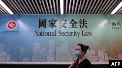 行人走过香港街头港版国安法的宣传牌。（2020年7月28日）