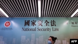 行人走過香港街頭港版國安法的宣傳牌。（2020年7月28日）