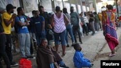 Migrantes de Haití hacen fila para regularizar su situación migratoria fuera de la Comisión Mexicana de Ayuda a Refugiados (COMAR), en Tijuana, México, el 29 de septiembre de 2021.
