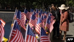Des visiteurs regardent les drapeaux américains sur le mémorial du 11-Septembre à New York, le 10 septembre 2022, un jour avant le 21e anniversaire des attaques de 2001.