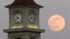 ARCHIVO: La Luna vista detrás de la torre con reloj de Home Place, el 22 de junio de 2013, en Prattville, Alabama. 