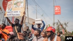 Waandamanaji wa DRC wakiwa wamebeba jeneza na bango lenye picha za rais wa Rwanda Paul Kagame na Uganda Yoweri Museveni. Waandamanaji wanadai kwamba Uganda na Rwanda zinaunga mkono waasi wa M23 Okt 31, 2022