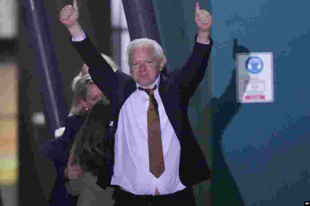 WikiLeaks founder Julian Assange gestures after landing at RAAF air base Fairbairn in Canberra, Australia. Assange has returned to his homeland Australia aboard a charter jet hours after pleading guilty to obtaining and publishing U.S. military secrets in a deal with Justice Department prosecutors that concludes a drawn-out legal saga.