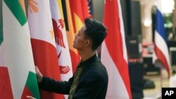 東盟國家聯盟(ASEAN)十國外長和中國官員2023年7月10號在印度尼西亞首都雅加達舉行避免在南中國海地區發生重大武裝衝突會議。一位印尼工作人員正在整理國旗。