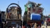 Pengungsi Afghanistan duduk di samping barang-barang mereka di pusat pendaftaran setibanya mereka dari Pakistan, dekat perbatasan Afghanistan-Pakistan di distrik Spin Boldak di provinsi Kandahar, 20 November 2023. (Sanaullah SEIAM/AFP)