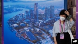 Seorang perempuan mengenakan masker saat berada di sebuah area di Shanghai, pada 6 Juli 2023. (Foto: AP/Ng Han Guan)