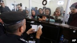 فلسطینی‌های دارای تابعیت‌ دوگانه برای عبور از گذرگاه مرزی رفح در نوار غزه با مامور مصری صحبت می‌کنند ۱۱ آبان ۱۴۰۲. (عکس آسوشیتدپرس/ حاتم علی)