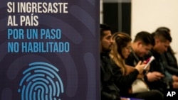ARCHIVO - Migrantes esperan su turno para ser registrados a través de una campaña de registro biométrico, en una oficina de investigación policial, en Santiago, la capital de Chile, el martes 11 de julio de 2023.