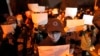 FILE - Protesters hold up blank papers and chant slogans as they march in protest in Beijing, Nov. 27, 2022.