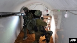 ARCHIVO: Esta foto tomada el 8 de febrero de 2024 durante un recorrido de la prensa organizado por el Ejército israelí, muestra a soldados israelíes dentro de un túnel que según el Ejército era un puesto de mando de Hamás debajo de la sede de UNRWA en la Ciudad de Gaza.