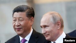 FILE - Chinese President Xi Jinping and Russian President Vladimir Putin attend a presentation of a Haval F7 SUV produced at the Haval car plant located in Russian Tula region, at the Kremlin in Moscow, Russia, June 5, 2019. 
