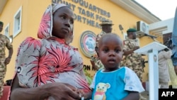 Mwanafunzi aliyekuwa ametekwa nyara akiwa na mtoto wake katika kambi ya jeshi ya Maimalari huko Maiduguri Nigeria Juni 21, 2022. Picha na Audu MARTE / AFP