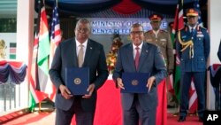 Sekrete Defans Etazini Lloyd Austin (a goch) ak Sekrete Kabine Kenya pou Defans Aden Duale kenbe ako kowoperasyon defans bilateral yo sot siyen nan Nairobi, Kenya, 25 Sept. 2023. 