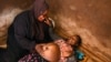ARCHIVO - Una partera tradicional atiende a una mujer embarazada en su casa, en Simika Village, Chiradzulu, sur de Malawi, el 23 de mayo de 2021.