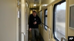 El presidente de Ucrania, Volodymyr Zelenskyy, camina por un pasillo a su llegada para una entrevista con The Associated Press en un tren camino de la región de Sumy a Kiev, Ucrania, el martes 28 de marzo de 2023. (AP Foto/Efrem Lukatsky )