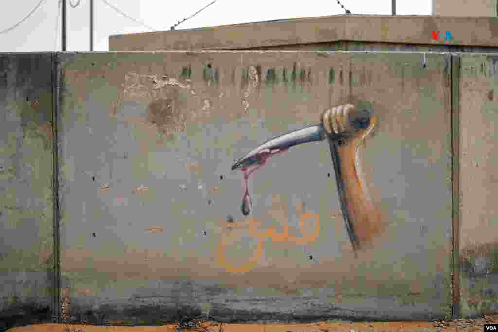 Grafiti de un cuchillo ensangrentado en una de las paredes de Little Gaza. El centro de entrenamiento ha sido acondicionado para simular lo más real posible a una ciudad árabe, según las Fuerzas de Defensa de Israel. 