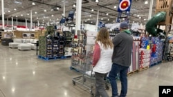 ARCHIVO - Compradores revisan los productos en un almacén de Costco el domingo 25 de febrero de 2024 en Sheridan, Colorado. 