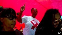 FILE - A woman dances as she listens to music while attending a World AIDS Day commemoration at Nkosi's Haven in Johannesburg on Nov. 30, 2019 on the eve of World AIDS Day. 