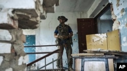 一名烏克蘭軍人在新近收復的頓涅茨克州布拉霍達特內村查看一座已經千瘡百孔的文化中心。(2023年6月16日)