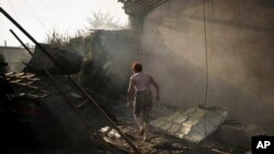 乌克兰赫尔松地区一名妇女走在被俄罗斯炸毁的房屋前。(2023年6月9日)