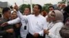 Capres Anies Baswedan menunjukkan jarinya yang telah tercelup tinta setelah menggunakan hak pilih bersama istrinya Fery Farhati Ganis, di TPS Lebak Bulus, Jakarta, pada 14 Februari 2024. (Foto: Reuters/Ajeng Dinar Ulfiana)