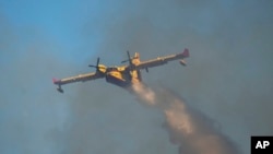 Kanader gasi vatru iznad grčkih sela (Foto: AP/Petros Giannakouris)