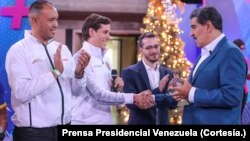 El presidente venezolano Nicolás Maduro saluda a u grupo de deportistas durante la transmisión de su programa televisivo, la noche del lunes 18 de diciembre de 2023.