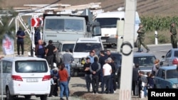 People, including Armenian service members and refugees from Nagorno-Karabakh, gather at a checkpoint in the village of Kornidzor, Armenia, Sept. 24, 2023.