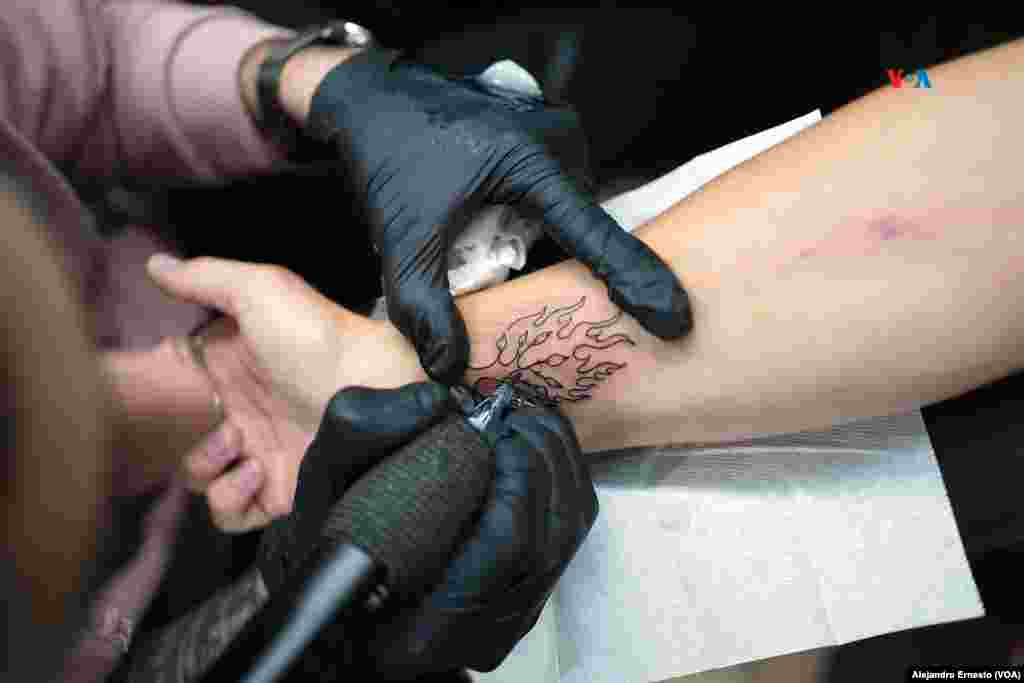 Uno de los tatuadores de la familia Razzouk dibuja un árbol en llamas en el brazo de un cliente en su estudio en Jerusalén. 
