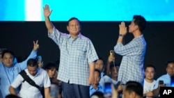 Indonesian presidential candidate Prabowo Subianto, left, and his running mate Gibran Rakabuming Raka, the eldest son of Indonesian President Joko Widodo, greet supporters during a gathering in Jakarta, Feb. 14, 2024. 