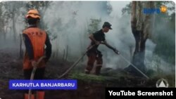 Petugas berupaya memadamkan api kebakaran hutan di Ulis Selantan, Kec.Lianganggang, Banjarbaru, Kalimantan Selatan, Minggu, 23 Juli 2023. (Foto: YouTube/@BNPBIndonesia)