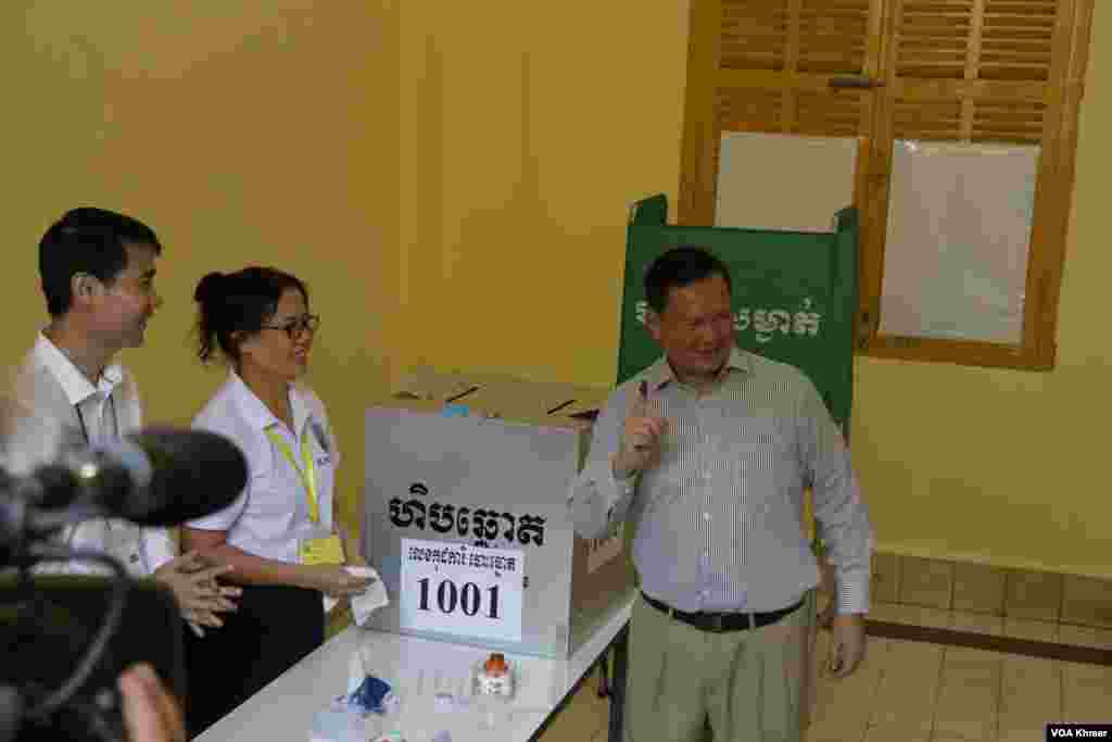 លោក ហ៊ុន ម៉ាណែត នាយករដ្ឋមន្រ្តីកម្ពុជា និងជាតំណាងរាស្រ្តមណ្ឌលភ្នំពេញ លើកដៃជ្រលក់ទឹកថ្នាំ ក្រោយការបោះឆ្នោតជ្រើសរើសសមាជិកព្រឹទ្ធសភា នៅមណ្ឌលបោះឆ្នោតវិទ្យាល័យព្រះស៊ីសុវត្ថិ ក្នុងរាជធានីភ្នំពេញ នាថ្ងៃទី២៥ ខែកុម្ភៈ ឆ្នាំ២០២៤។ (ស៊ុន ណារិន/វីអូអេ)