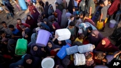شماری از فلسطینیها که در اثر حملات هوایی اسراییل در نوار غزه به یکی از کمپهای موقتی خان یونس پناه بردهاند، برای دسترسی به آب صف کشیدهاند