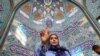 Seorang perempuan Iran menunjukkan jari yang sudah dicelup di tinta dalam pilpres untuk memilih pengganti mendiang Presiden Ebrahim Raisi, di Teheran, Iran, Jumat, 28 Juni 2024. (Foto: Majid Asgaripour/WANA via Reuters)