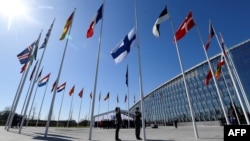 FILE - Finnish military personnel hoist the Finnish national flag at the NATO headquarters in Brussels, as Finland became the 31st member of NATO April 4, 2023.