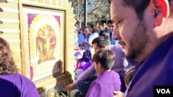 Como parte de la tradición presentan a los niños frente a la imagen del Señor de los Milagros.