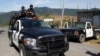 ARCHIVO - En esta fotografía del 28 de abril de 2010, la policía estatal custodia la entrada al pueblo de San Juan Copala, México, después de que hombres armados tendieran una emboscada a una caravana de activistas de derechos humanos.