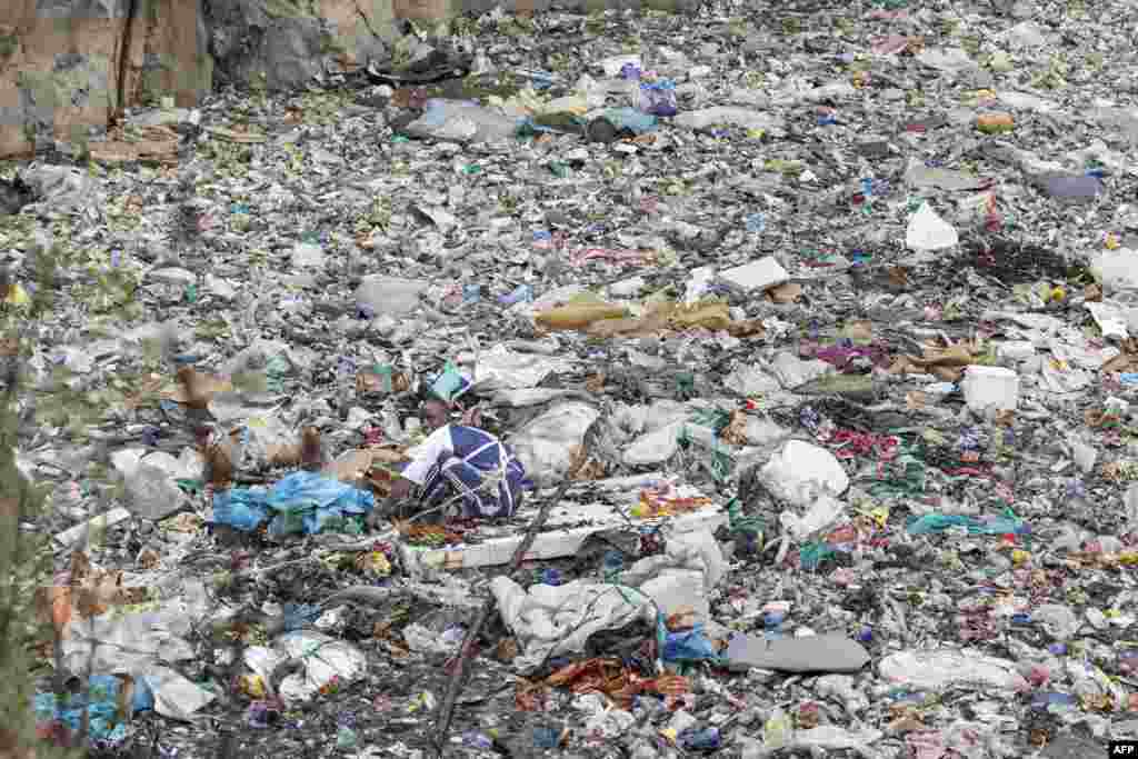 A volunteer searches through a rubbish dump for human remains at Mukuru slum in Nairobi, Kenya, July 14, 2024. Eight female bodies have been recovered so far from a dumpsite in a Nairobi slum. The mutilated and dismembered bodies, trussed up in plastic bags, were hauled out of a sea of floating rubbish in the abandoned quarry.