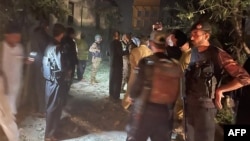 Petugas keamanan berkumpul di lokasi setelah beberapa ledakan yang disebabkan oleh kebakaran di gudang amunisi di kantor polisi Pakistan di Kabal, di Lembah Swat, pada 24 April 2023. (Foto: AFP)