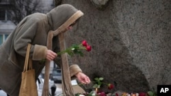 Фото 21 лютого 2024 року: жінка вшановує пам'ять російського опозиціонера Олексія Навльного, який помер у в'язниці 16 лютого у віці 47 років