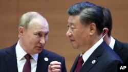 资料照片:2022年9月16日,俄罗斯总统普京在乌兹别克斯坦撒马尔罕举行的上海合作组织峰会上与中国国家主席习近平交谈时做手势。(美联社照片)