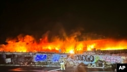 Esta fotografía proporcionada por el Departamento de Transporte de California muestra un incendio temprano en la mañana a lo largo de la Interestatal 10 cerca del centro de Los Ángeles, el sábado 11 de noviembre de 2023.