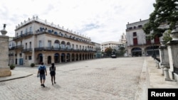 Dos personas transitan por una calle vacía de La Habana, Cuba, el 8 de junio de 2024.