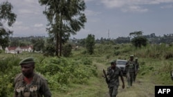 Waasi wa kundi la M23 wakilinda eneo hilo wakati wa mkutano kati ya maafisa wa Kikosi cha Afrika Mashariki (EACRF) na waasi wa M23 katika kambi ya Rumangabo huko DRC Januari 6, 2023. Picha na Guerchom Ndebo/AFP